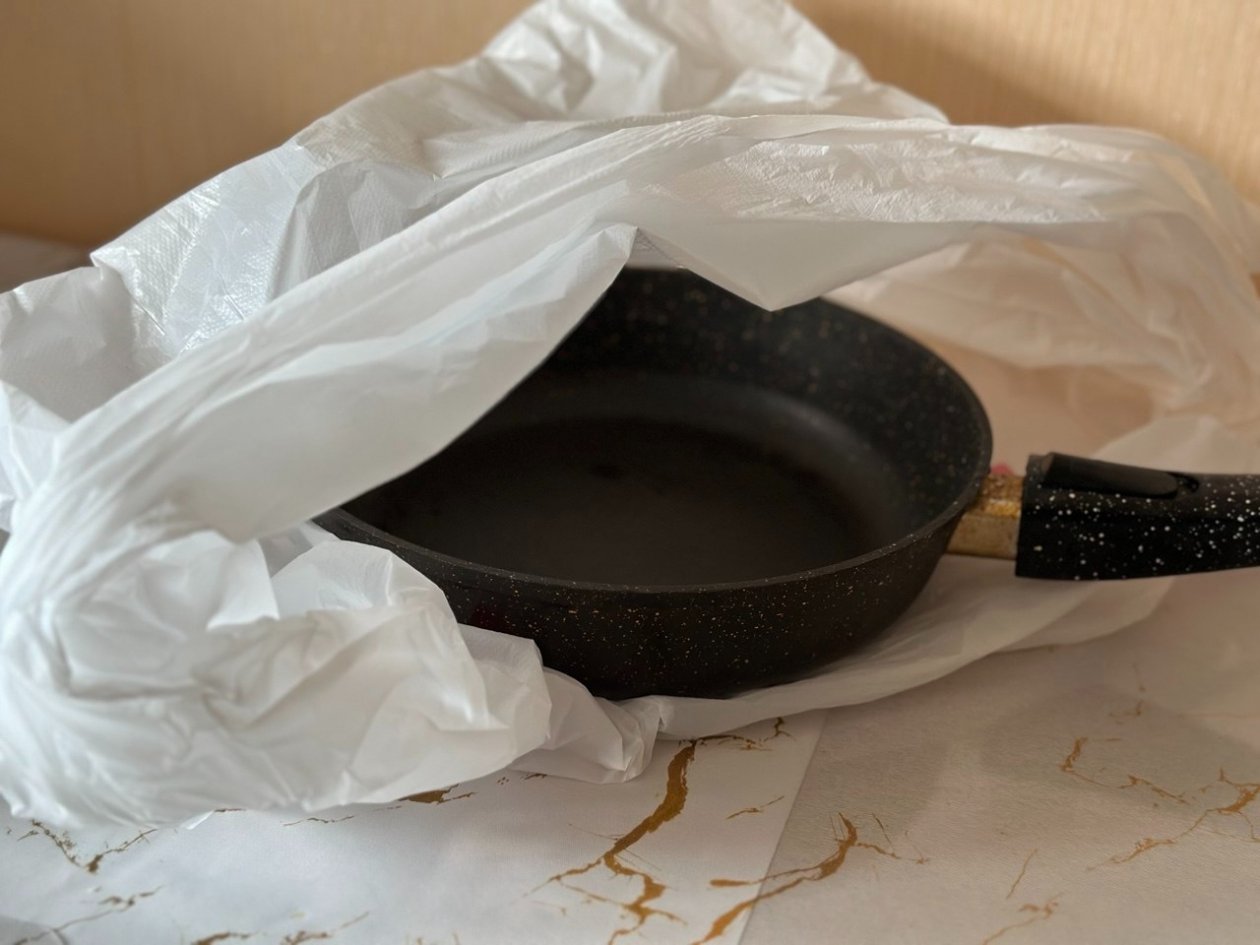 Пакую сковороду в пакет, и нагар легко отлетает ошметками - красуюсь в отражении ИА KrasnodarMedia